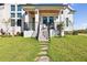 Inviting covered front porch with seating, stone steps and minimalist landscaping in front at 3705 Ridge Run Dr, Minneola, FL 34715