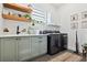 Modern laundry room with gray cabinetry, stylish decor, and black appliances at 3705 Ridge Run Dr, Minneola, FL 34715