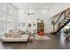 Bright living room with a modern staircase, high ceilings, and comfortable seating area at 3705 Ridge Run Dr, Minneola, FL 34715