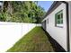 Landscaped backyard with a white fence and grassy area at 5049 Lake Howell Rd, Winter Park, FL 32792