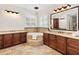 Elegant bathroom with double vanity, soaking tub, and large mirror at 5049 Lake Howell Rd, Winter Park, FL 32792