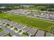 Aerial view showing a well-planned community with neatly arranged homes, green spaces, and convenient road access at 7836 June Ln, Wildwood, FL 34785