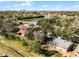 Aerial view of a single-Gathering home on a tree-lined street, near a lake at 825 Kottle S Cir, Daytona Beach, FL 32114
