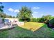 Manicured backyard featuring a built-in grill, stone patio, lush lawn, and mature trees for privacy at 1219 Verdant Glade Pl, Winter Park, FL 32792
