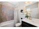 Well-lit bathroom featuring a shower-tub combo with a gray tiled wall and a stylish vanity with gold fixtures at 1219 Verdant Glade Pl, Winter Park, FL 32792