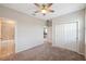Bedroom with neutral walls, carpet, fan and a view of the bathroom and hallway at 1219 Verdant Glade Pl, Winter Park, FL 32792