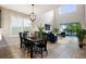 Elegant dining area features modern light fixture, adjacent to a bright living room with high ceilings and large windows at 1219 Verdant Glade Pl, Winter Park, FL 32792