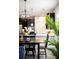 Dining area with stylish lighting fixture and decor, connected to a modern kitchen with white countertops and stainless steel appliances at 1219 Verdant Glade Pl, Winter Park, FL 32792