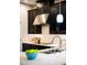 A kitchen features dark cabinetry, quartz countertops, stainless steel vent hood and undermount lighting at 1219 Verdant Glade Pl, Winter Park, FL 32792