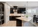 A stylish black and white kitchen features modern stainless steel appliances and a large island with seating at 1219 Verdant Glade Pl, Winter Park, FL 32792