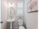 A charming powder room features a pedestal sink, oval mirror, and stylish decorative art at 1219 Verdant Glade Pl, Winter Park, FL 32792
