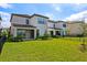 A beautifully landscaped backyard features lush grass, a covered patio, and manicured shrubbery at 1312 Blue Stem Ln, Winter Park, FL 32792