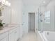Bright bathroom boasts a glass shower, soaking tub, white marble tile, and white vanity at 1312 Blue Stem Ln, Winter Park, FL 32792