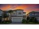Two-story home showing modern architectural details, a two-car garage and a beautifully landscaped front yard at sunset at 1312 Blue Stem Ln, Winter Park, FL 32792