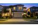 Charming two-story home with a two-car garage, paved driveway and landscaped front yard at dusk at 1312 Blue Stem Ln, Winter Park, FL 32792