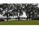 A view across the green lawn towards the pond, showing lush trees and homes of the surrounding community at 1312 Blue Stem Ln, Winter Park, FL 32792