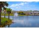 A scenic view of a community pond with a fountain, surrounded by lush landscaping at 1312 Blue Stem Ln, Winter Park, FL 32792