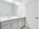 Bathroom featuring double sinks with quartz countertops and modern gray cabinetry and a large vanity mirror at 142 Jones Fish Camp Rd, Edgewater, FL 32141