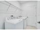Laundry area with white washer and dryer, metal shelving, and neutral walls at 142 Jones Fish Camp Rd, Edgewater, FL 32141