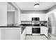 Modern kitchen with white cabinets, stainless steel appliances, and dark countertops at 304 E South St # 5029, Orlando, FL 32801