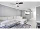 Modern living room with gray walls, hardwood floors, ceiling fan, and sectional sofa, plus views to the kitchen at 304 E South St # 5029, Orlando, FL 32801