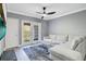 Living room with large TV, sectional sofa, and access to balcony at 304 E South St # 5029, Orlando, FL 32801