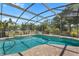 View of backyard with an inviting screened-in pool with brick pavers and mature landscaping at 3871 Dallas Blvd, Orlando, FL 32833