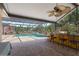 Poolside covered bar area with ample seating, brick patio, and overhead lighting for outdoor entertainment and relaxation at 3871 Dallas Blvd, Orlando, FL 32833