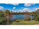 Scenic view of a serene lake surrounded by lush greenery, with a city skyline in the distance at 450 Cherokee Dr, Orlando, FL 32801