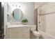 Classic bathroom features a tub/shower combination, white vanity with marble countertop and a round mirror at 450 Cherokee Dr, Orlando, FL 32801