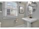 Elegant bathroom with pedestal sink, gold fixtures, and window with blinds at 450 Cherokee Dr, Orlando, FL 32801