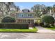 Two-story house with gray siding, brick accents, and a lush front yard at 450 Cherokee Dr, Orlando, FL 32801