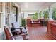 Spacious front porch featuring red tile floor and wooden chairs at 450 Cherokee Dr, Orlando, FL 32801