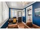 Bright home office with blue walls, comfortable seating, and a view of the kitchen at 450 Cherokee Dr, Orlando, FL 32801