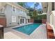 Backyard pool area with brick accents, lush privacy landscaping, and blue water at 450 Cherokee Dr, Orlando, FL 32801