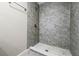 Modern shower with gray tile and hexagon floor at 4917 Tam Dr, Orlando, FL 32808