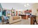 Open floor plan showcasing kitchen with barstool seating, dining area, and cozy living room with television at 564 Woodland Terrace Blvd, Orlando, FL 32828