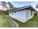 Side view of the house with gray trim detail and low retaining wall and green lawn at 731 Red Coach Ave, Deltona, FL 32725