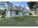 Side view of the home showcasing gray trim, window shutters and well-maintained lawn at 731 Red Coach Ave, Deltona, FL 32725