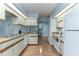 Bright kitchen with wood-look laminate flooring, white appliances, and a breakfast bar at 731 Red Coach Ave, Deltona, FL 32725