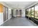 Screened patio with concrete floors, chair and entry door to the interior at 731 Red Coach Ave, Deltona, FL 32725