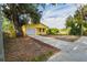 Charming yellow home featuring a garage, a well manicured yard, and a new driveway at 1235 19Th St, Orlando, FL 32805