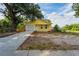 Charming yellow home featuring a garage, a well manicured yard, and a new driveway at 1235 19Th St, Orlando, FL 32805