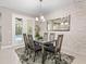 Bright dining room with glass table, modern chairs and pool view at 1484 Via Sangro Pl, Winter Park, FL 32792