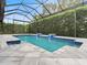 Inviting pool area with covered patio, water features, and gray tile deck at 1484 Via Sangro Pl, Winter Park, FL 32792