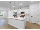 Modern kitchen features a central island with a sink, stainless steel appliances, and pendant lighting at 14962 Sw 39Th Cir, Ocala, FL 34473