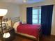 Small bedroom with brass bed frame and red bedding at 1520 Moravia Ave, Holly Hill, FL 32117