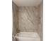 Bright bathtub and shower combo with white marble-style tile surround at 1621 Pear Ave, Sanford, FL 32771
