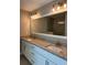 Bathroom with dual sinks, granite countertop, white cabinets, lighting and large mirror at 1621 Pear Ave, Sanford, FL 32771