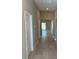 Hallway with gray walls, white trim and doors and neutral tile leading to other rooms in the home at 1621 Pear Ave, Sanford, FL 32771
